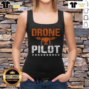 Expert drone pilot in a tank top skillfully flying a quadcopter, showcasing top RC flight operation skills.