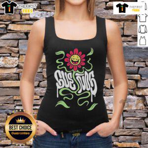 Happy festival-goer wearing a 'Pretty Suenos Music Festival' tank top, smiling amidst vibrant festival atmosphere.