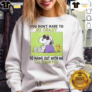 Alt Text: Cozy sweatshirt featuring Snoopy and Woodstock with the quote You don't have to be crazy to hang out with me.