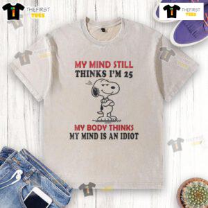 Funny Snoopy graphic on a washed t-shirt: 'My mind thinks I'm 25, my body thinks I'm an idiot.' Perfect for humor lovers!