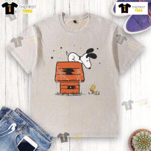 Pretty Snoopy and Woodstock haunted doghouse design on a washed t-shirt, perfect for Halloween fans and Peanuts lovers.