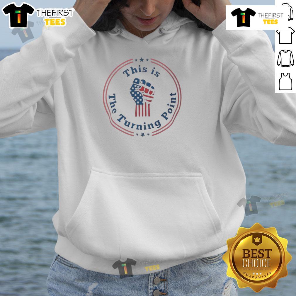 Charlie Kirk wearing a 'Top This is the Turning Point' hoodie with a fist and US flag design, symbolizing patriotism.