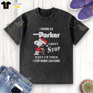 Cute Snoopy graphic on a Christmas T-shirt with 'I work at Parker Hannifin, I don't stop when I'm tired' slogan.