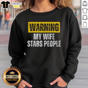 Alt Text: Vintage sweatshirt featuring the phrase Official Warning: My Wife Stabs People in bold letters.