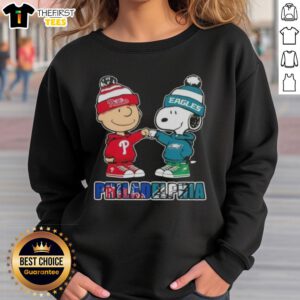 Pretty Charlie Brown fist bump with Snoopy on a Philadelphia sports sweatshirt featuring Phillies and Eagles logos.