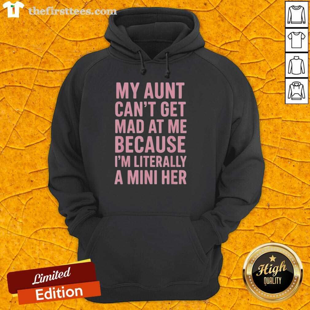 A young girl in a hoodie that says 'My Aunt Can't Get Mad At Me Because I'm Literally A Mini Her' smiling joyfully.
