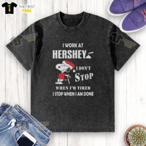Alt Text: Top Snoopy t-shirt featuring 'I work at Hershey, I dont stop when Im tired, I stop when Im done' design for Christmas.