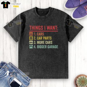 Person wearing a 'Top Things I Want: Car Parts, More Cars, Bigger Garage' t-shirt while standing in a garage.
