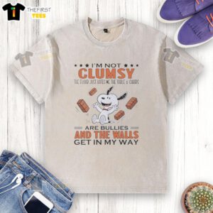 Alt Text: Cute Snoopy 'I'm Not Clumsy, The Floor Just Hates Me' T-Shirt featuring whimsical design with table and chairs