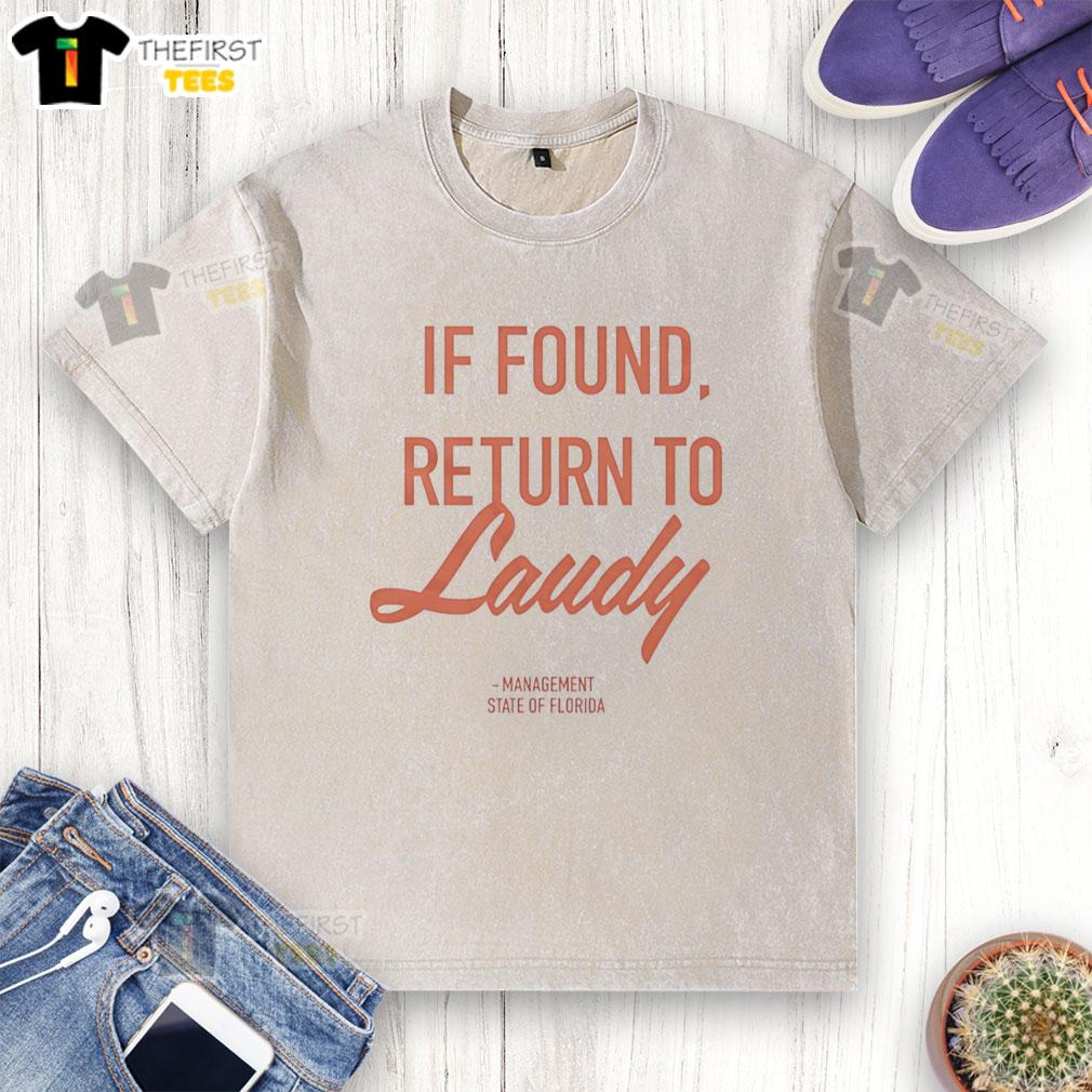 Top If Found Return To Laudy Management Florida washed t-shirt displayed on a wooden background, showcasing casual style.